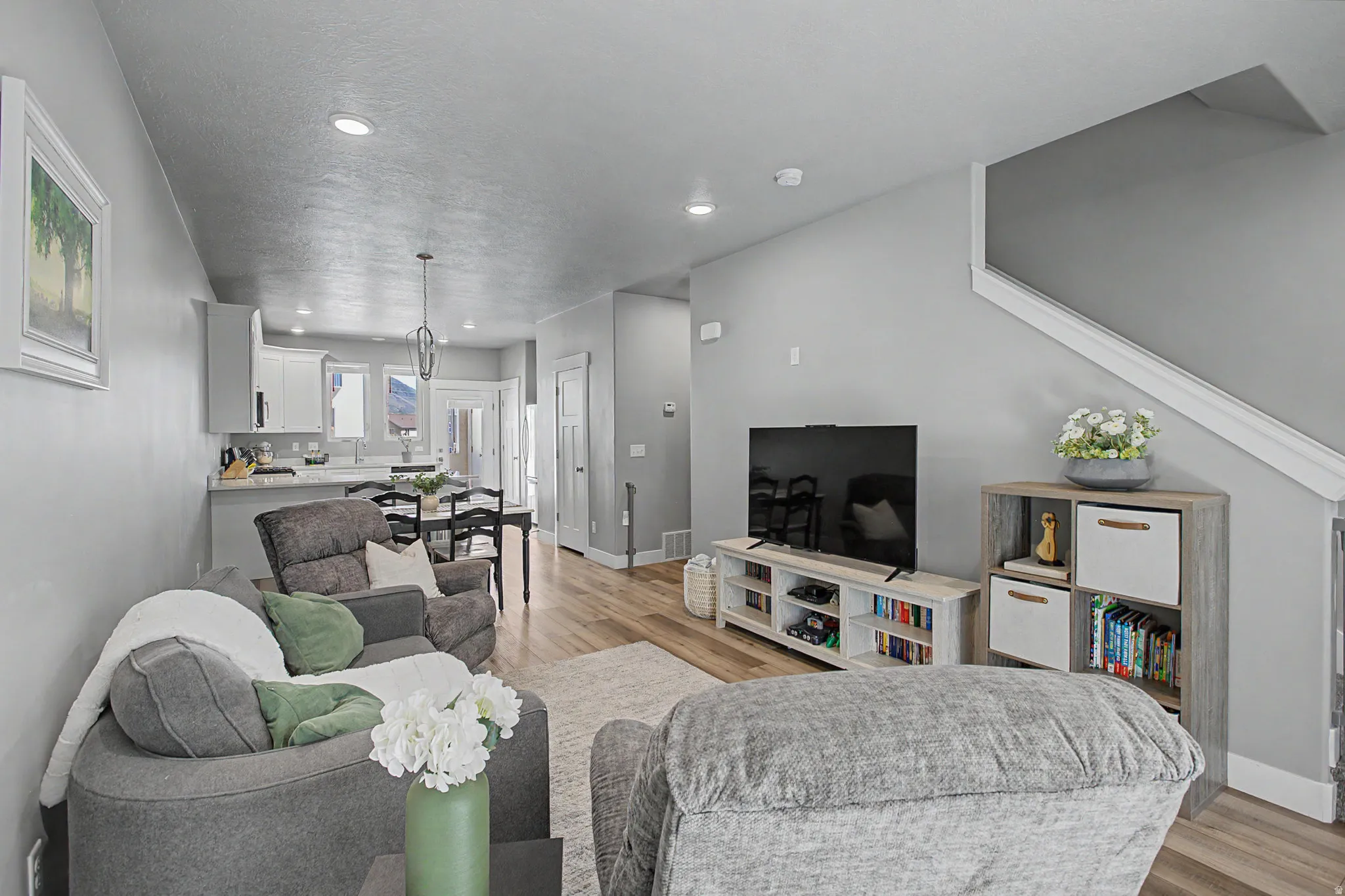 Open-concept living area featuring wood-finish flooring, recessed lighting, and a neutral wall color palette
