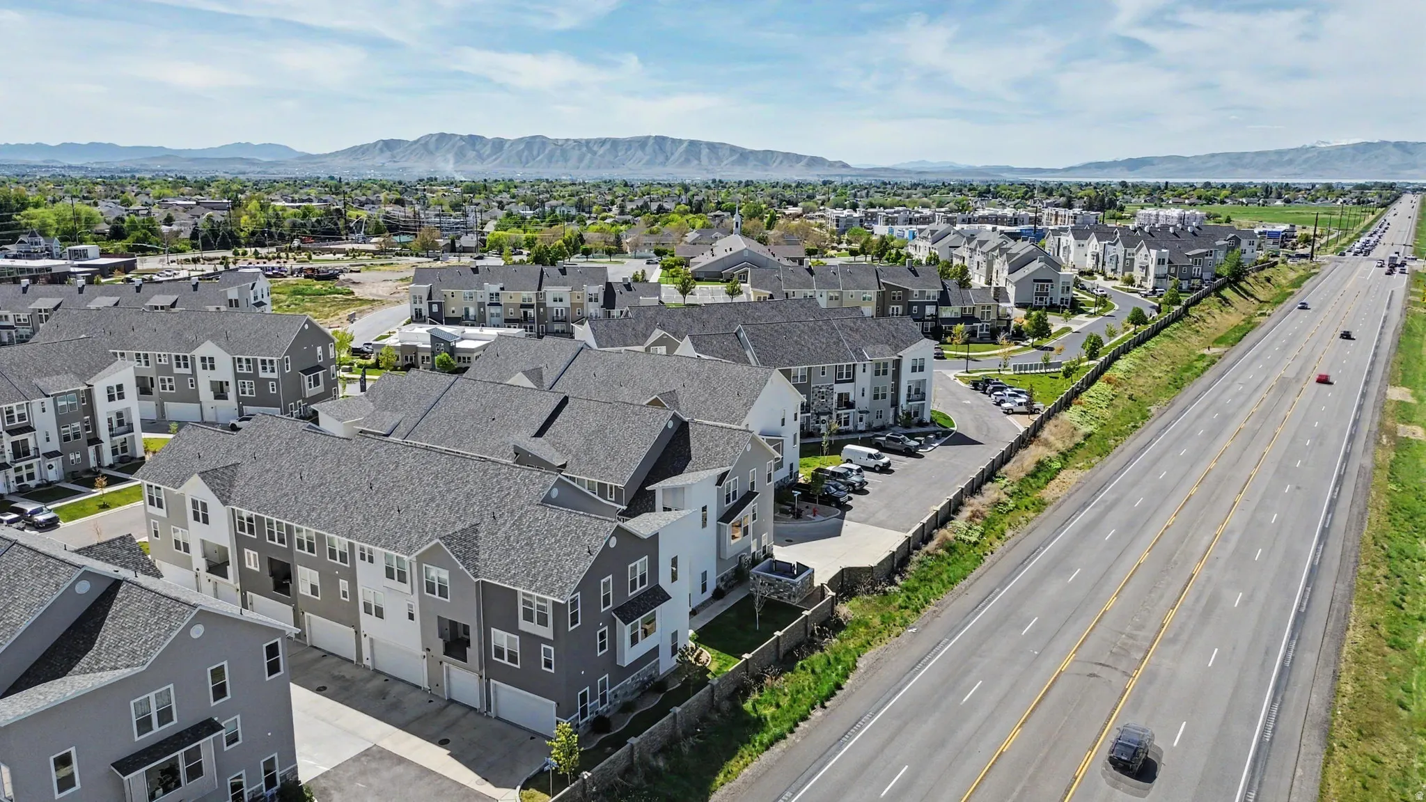 Modern multi-story residential buildings featuring grey shingle roofs and integrated garages