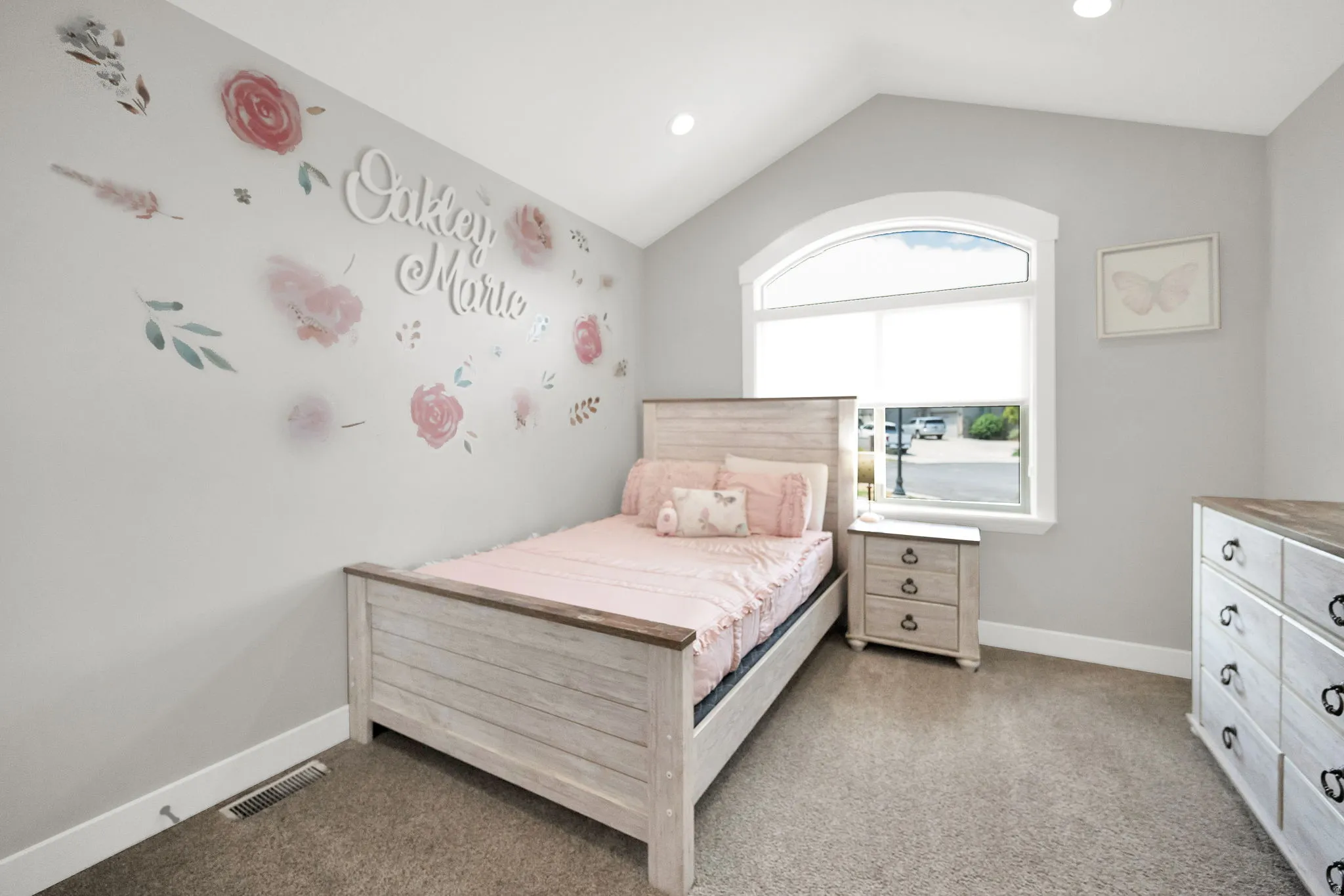 Vaulted ceiling bedroom featuring an arched window, recessed lighting, and neutral carpeting