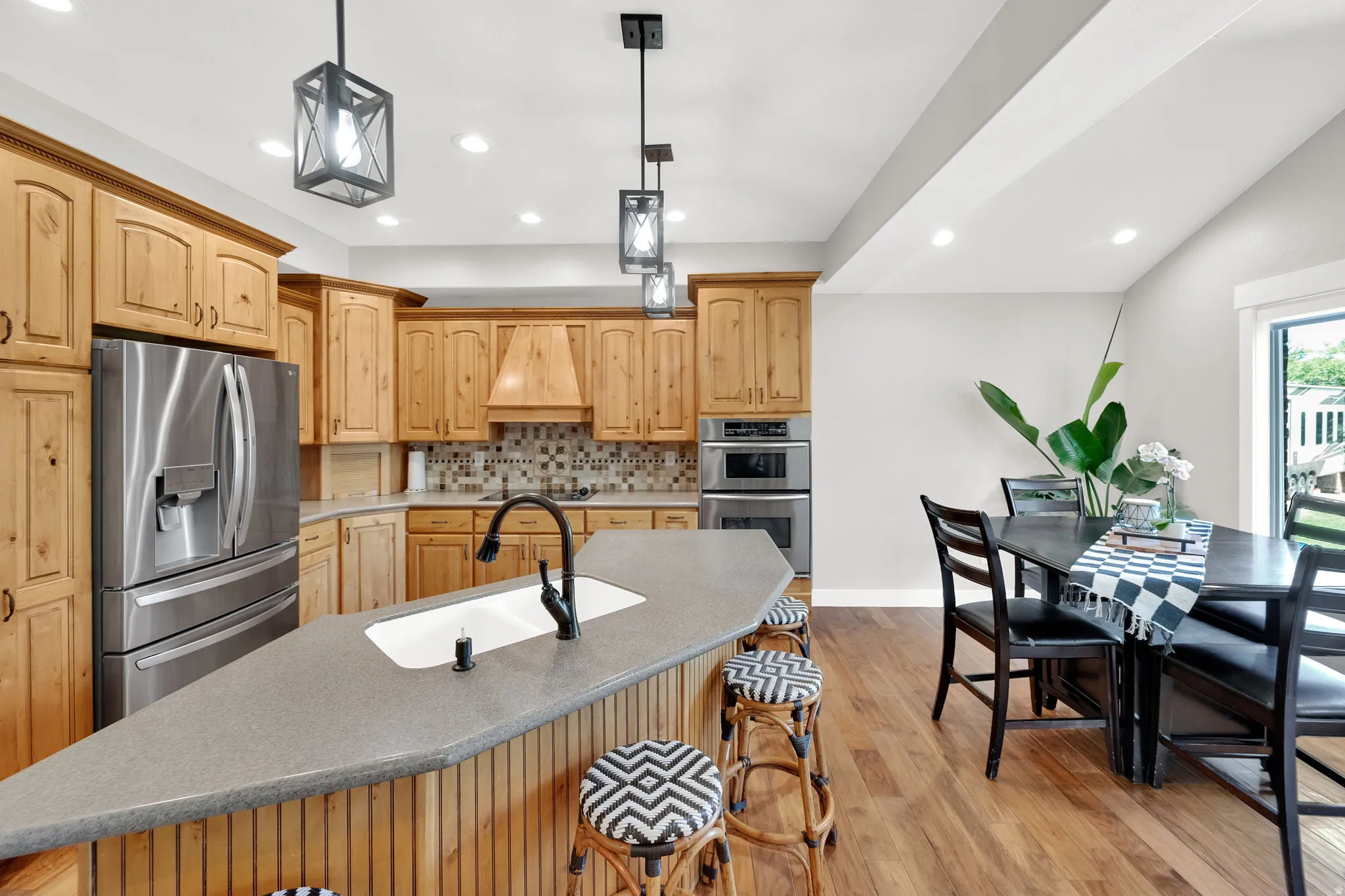 Modern kitchen featuring wood cabinetry, stainless steel appliances, and a tiled backsplash