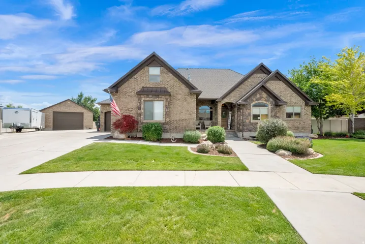 All brick and brick and stucco detached garage. an extended concrete driveway, mature landscaping, and a manicured lawn