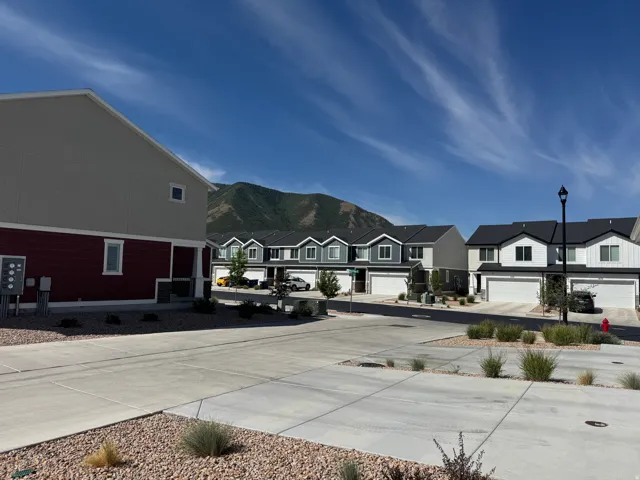 Modern townhome community featuring varied exterior siding, integrated garages, and mountain views