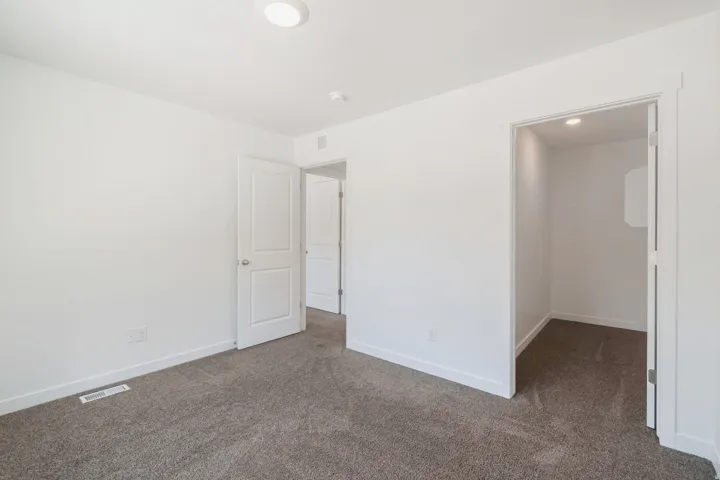 Neutral-toned wall-to-wall carpeting complements the bright white walls and trim