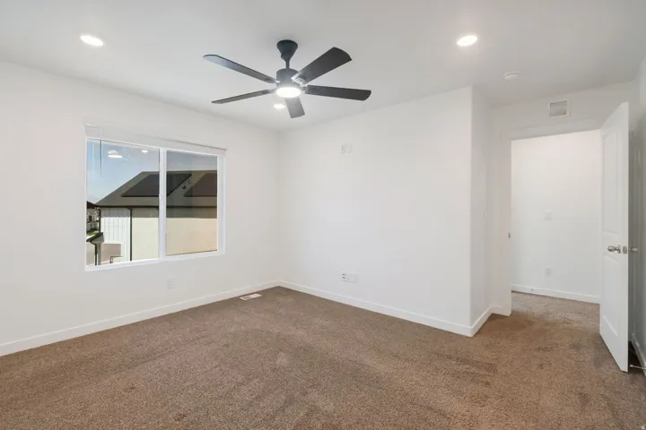Room featuring a large window, recessed lighting, and a modern ceiling fan with integrated lighting