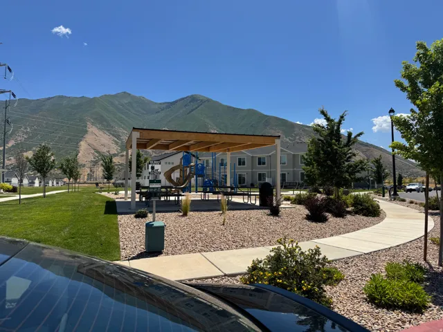 Community park area featuring a covered picnic pavilion, playground equipment, and mature landscaping
