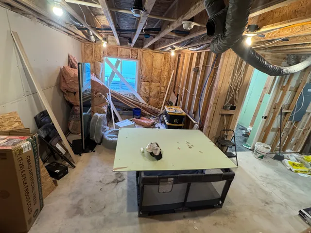 Unfinished interior space featuring exposed wood framing and partial drywall installation