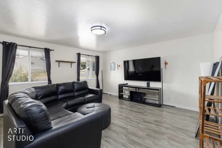 Living area featuring light wood-finish flooring and multiple windows