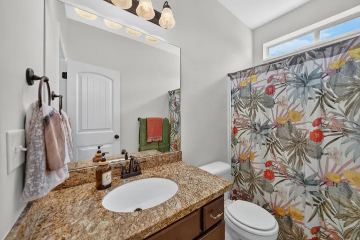 Vanity with an integrated oval sink and a granite-finish countertop