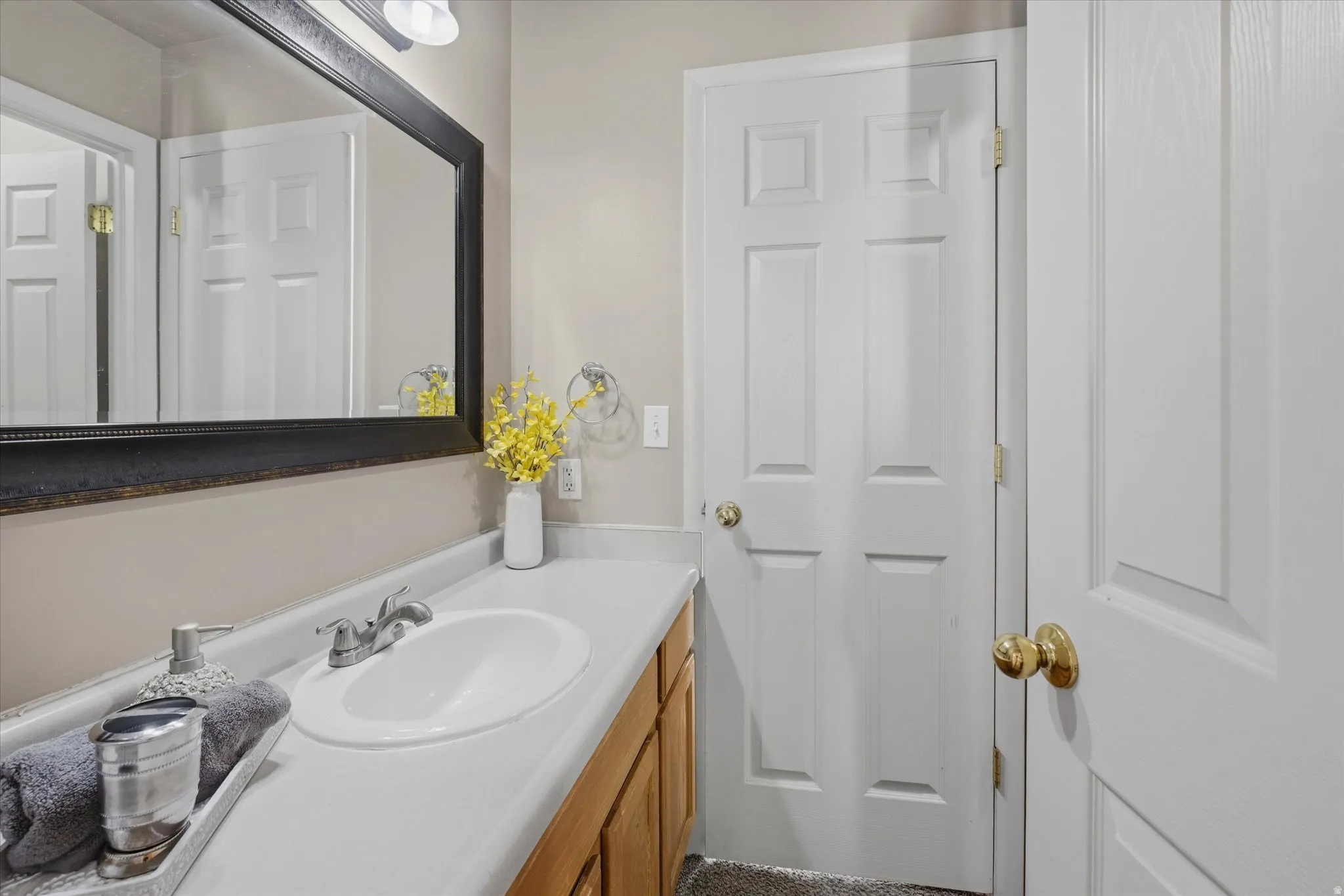 Bathroom vanity with a white countertop and an integrated sink, featuring a chrome faucet