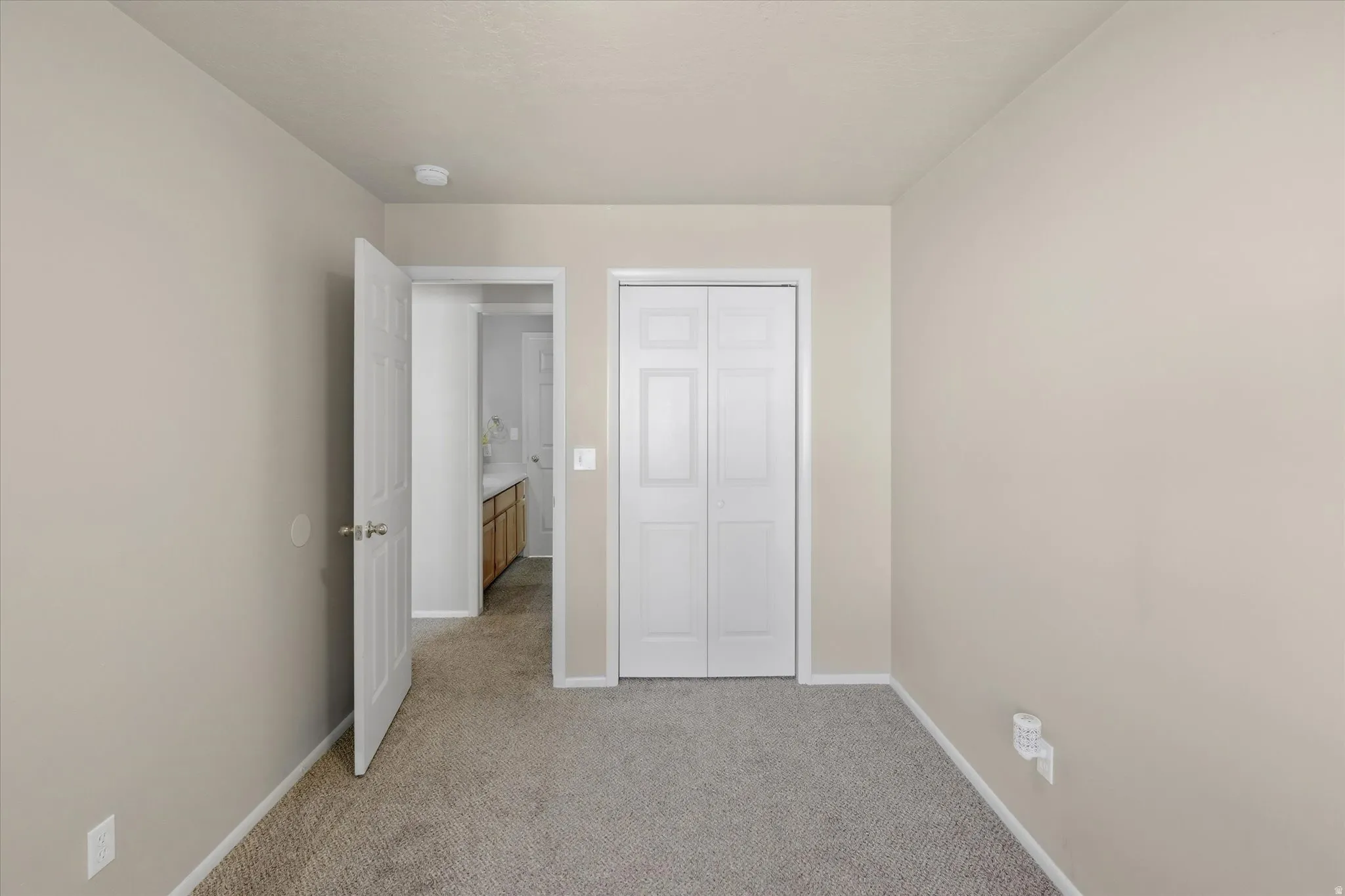 Neutral-toned walls complement the gray carpeting