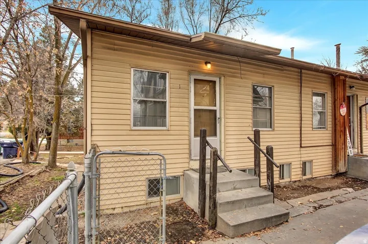 Exterior with horizontal siding, multiple windows, and a concrete staircase leading to an entry door
