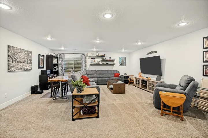 Spacious open-concept room with recessed lighting and neutral-toned carpeting