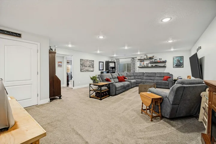 Spacious living area featuring neutral carpeting and recessed lighting