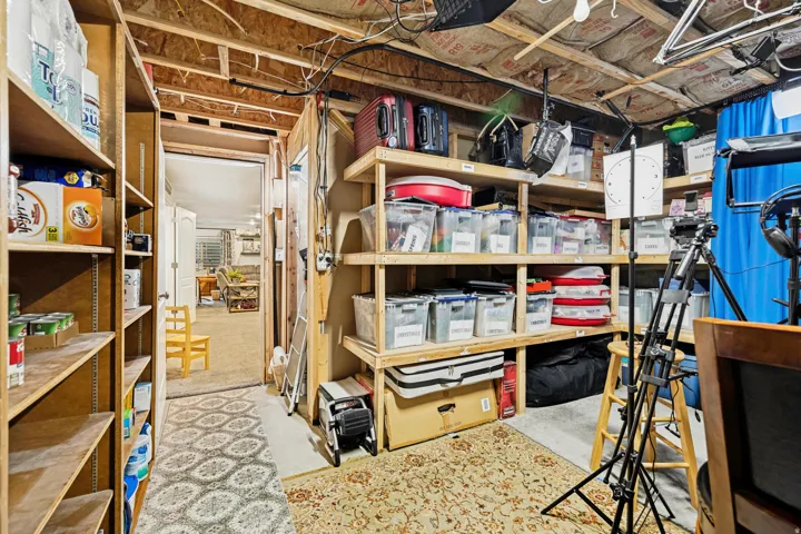 Unfinished basement area featuring exposed ceiling joists and insulation