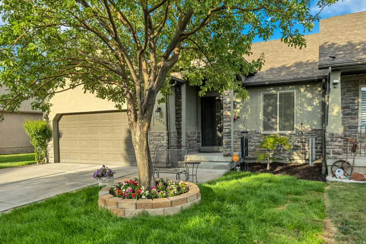 Stucco and stone facade with a prominent front entrance, an attached garage, and a concrete driveway