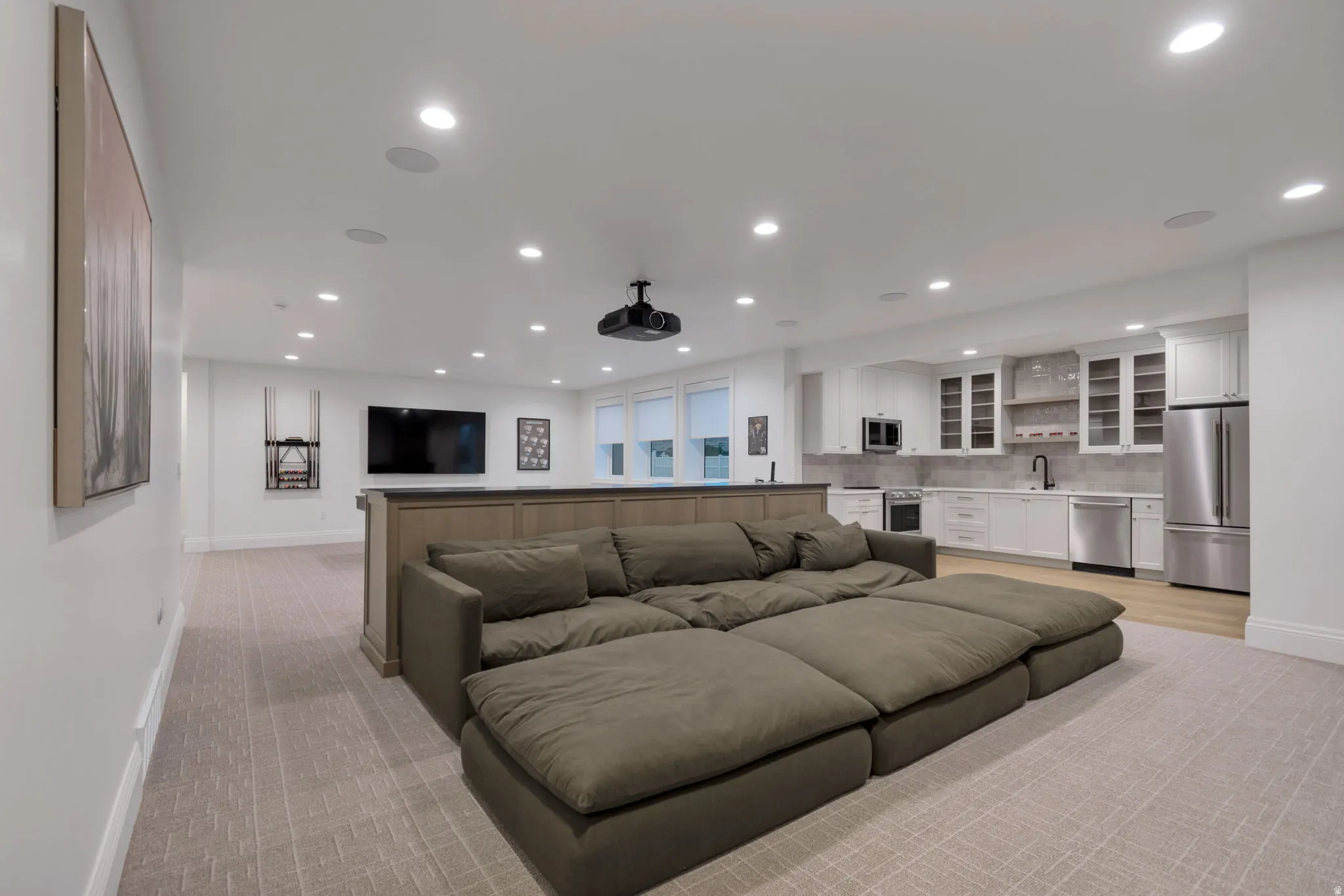 Spacious entertainment area featuring recessed lighting and projector