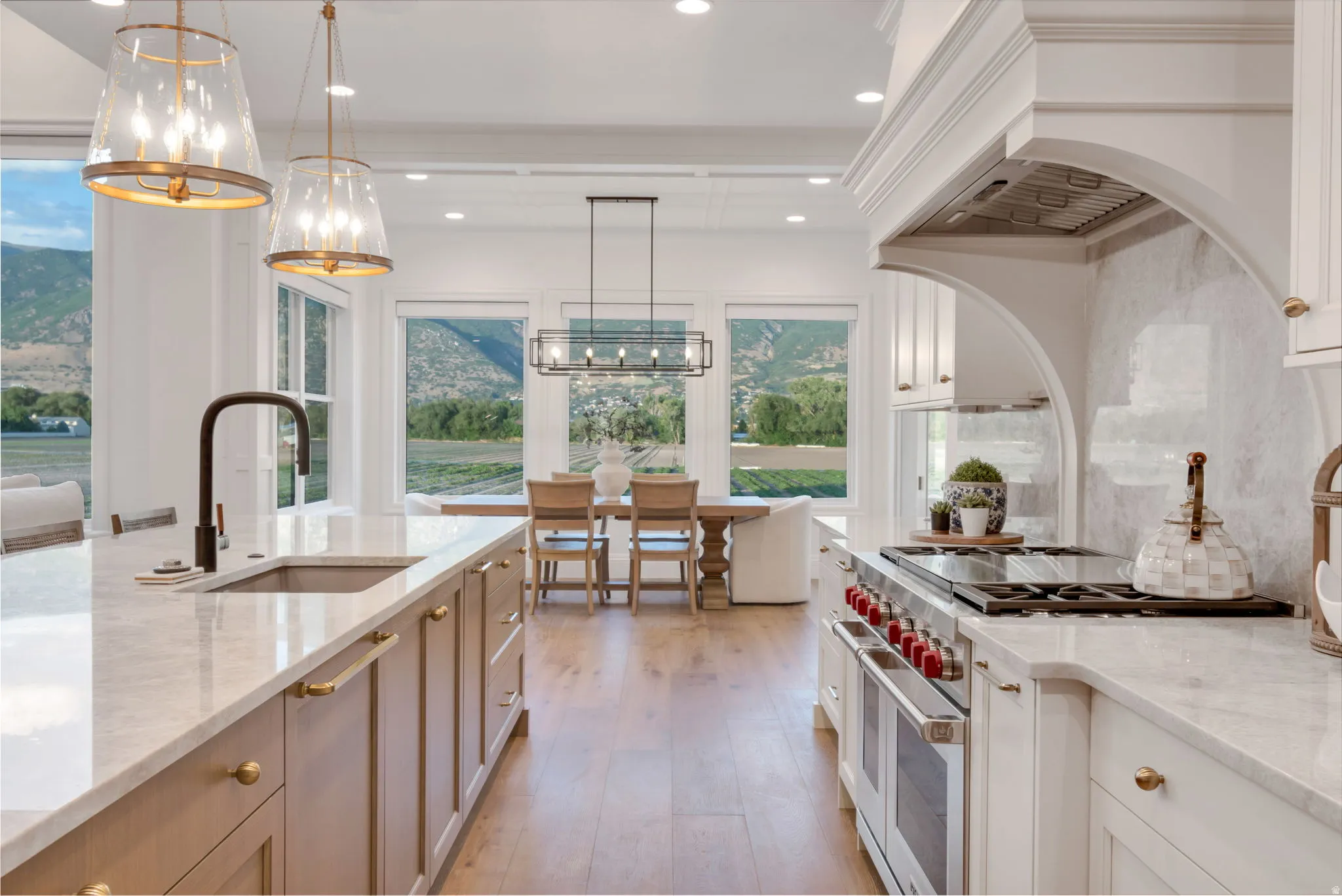Gourmet kitchen featuring a large island with an undermount sink and a professional-grade range with a custom hood