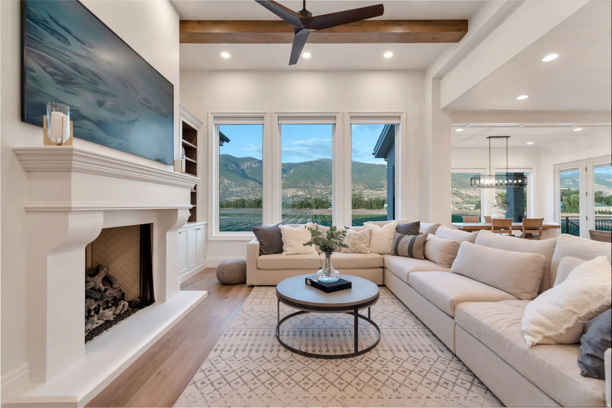 Living space featuring a prominent fireplace with a substantial mantel, built-in cabinetry, and wood-finish flooring