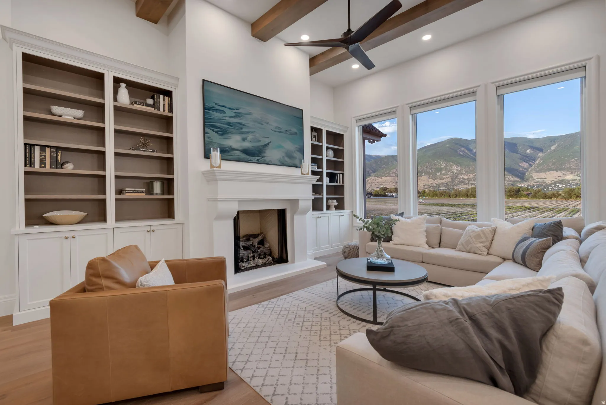 Living area with high ceilings, exposed wood beams, and a ceiling fan