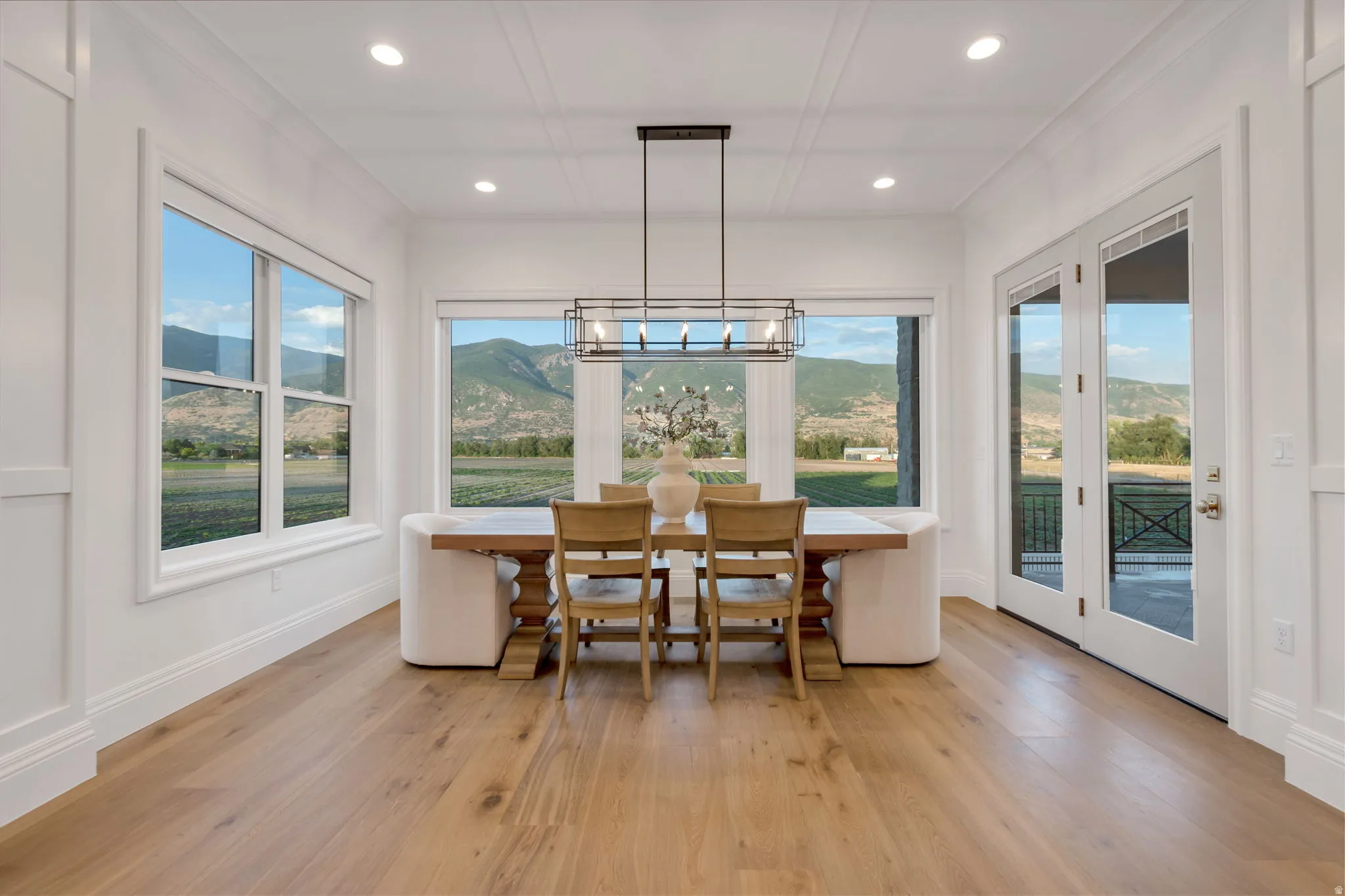 Light wood-finish flooring complements white paneled walls and extensive trim work