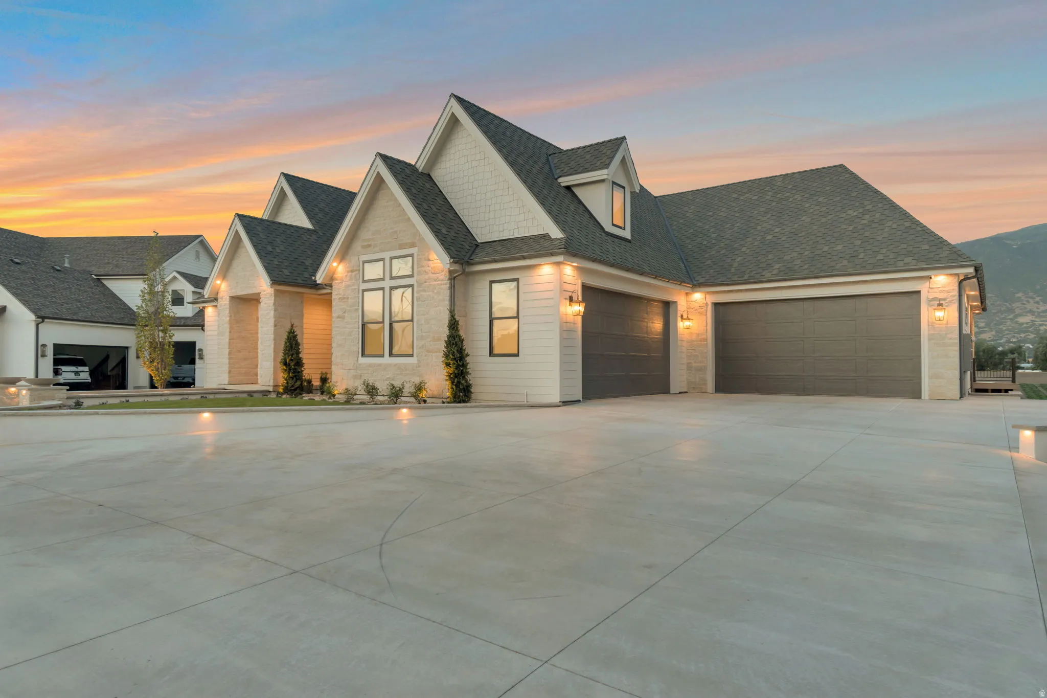 Contemporary home with a stone and siding exterior, multiple gables, and a prominent multi-car garage