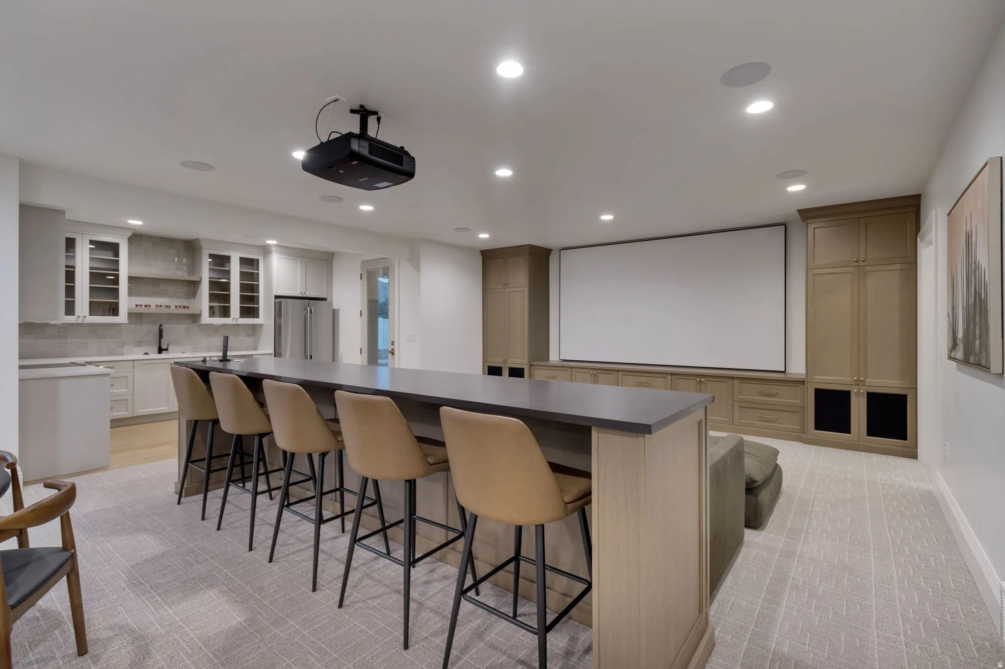 Entertainment room featuring a large projection screen, with full kitchen