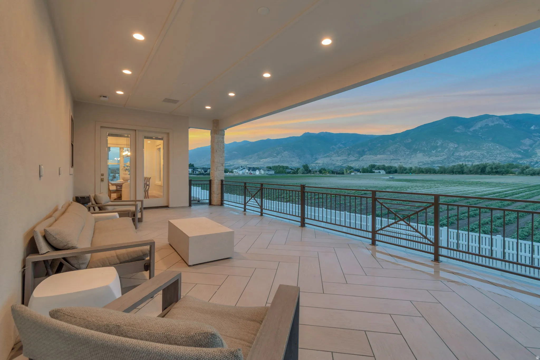 Spacious outdoor living area with a mountain backdrop, featuring  epoxy coating system and custom iron rail