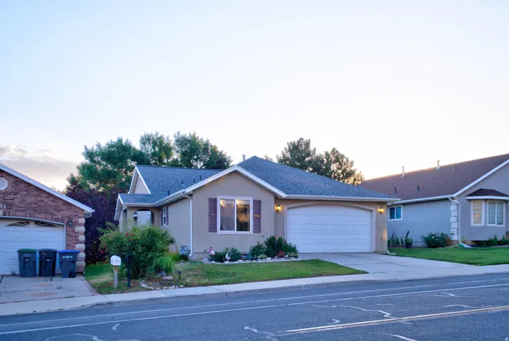 Stucco exterior with a pitched roof, two-car garage, and landscaped front yard