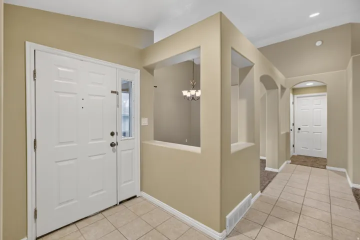 Entryway featuring a white paneled door with a sidelight, tile flooring, and neutral-toned walls