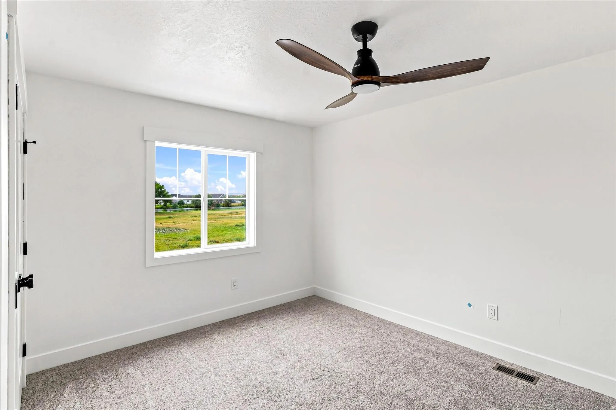 White interior walls, gray carpet, and a window with white trim