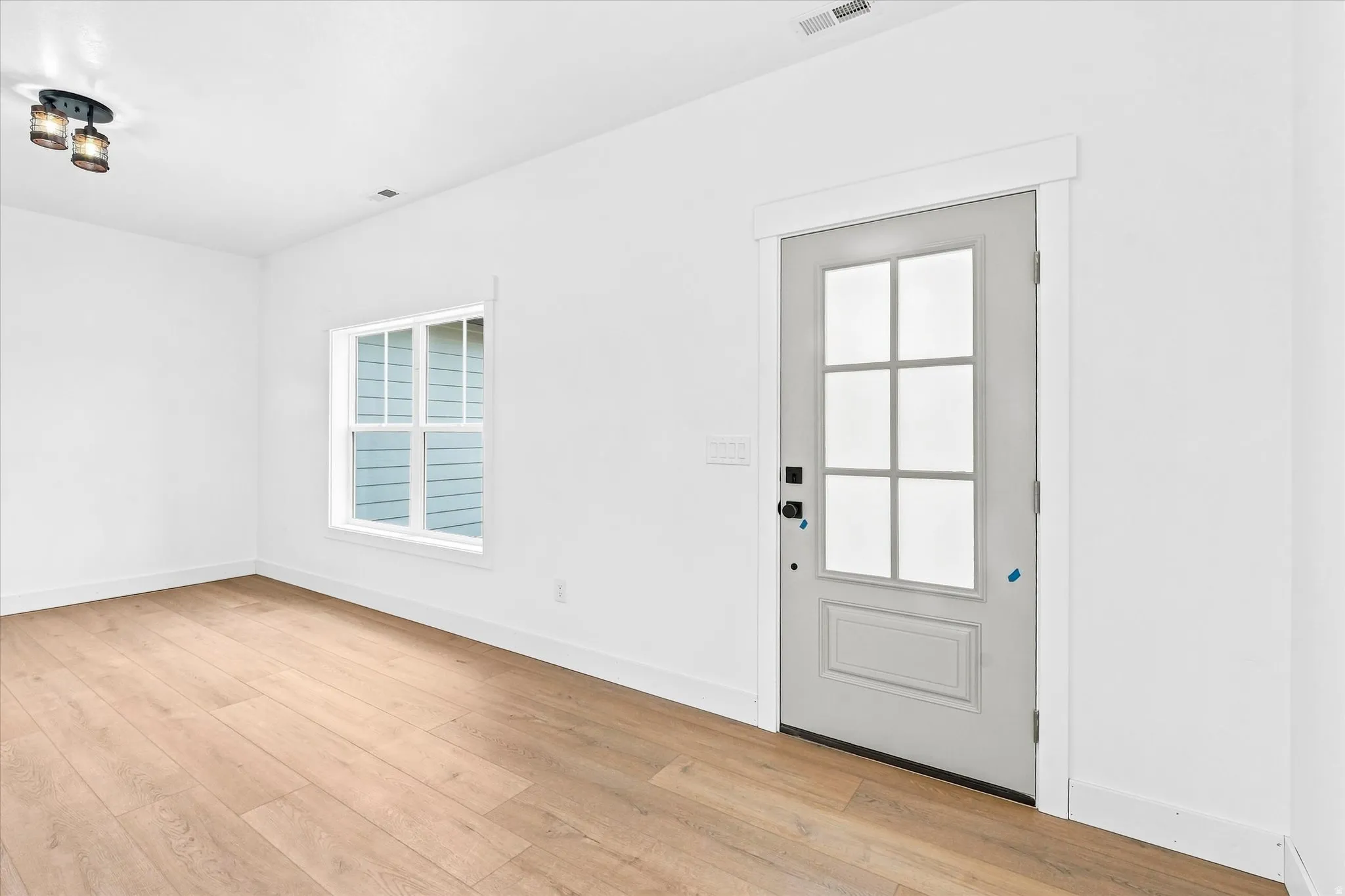 Light wood-finish flooring with white baseboards
