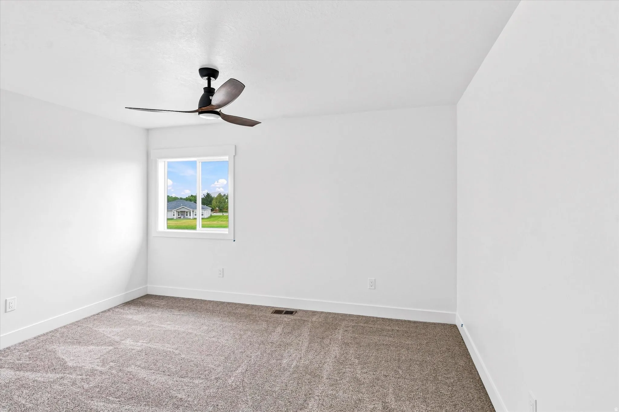 Recessed window with white trim, modern ceiling fan, and grey carpeting