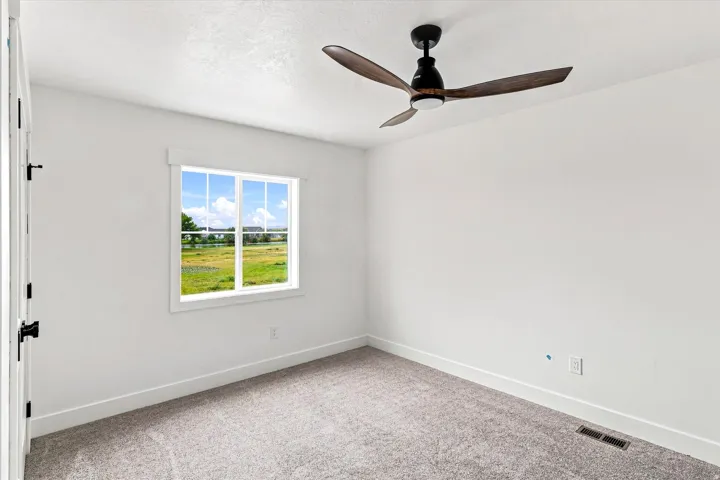 White interior walls, gray carpet, and a window with white trim
