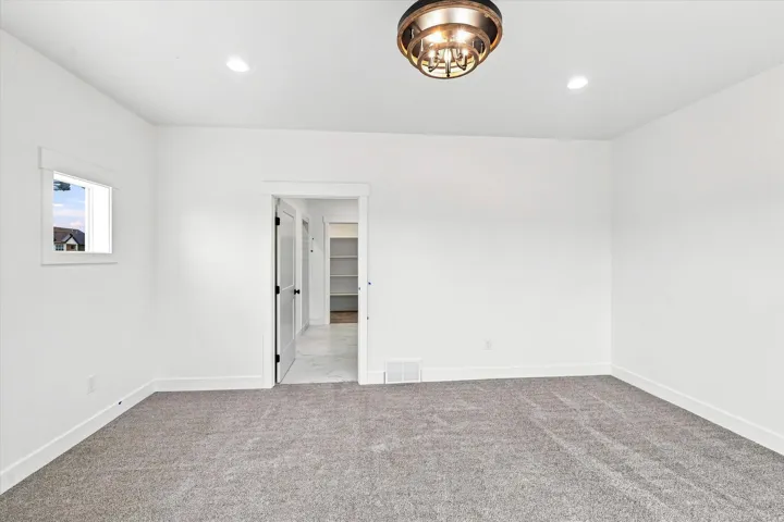 White walls with recessed lighting and a decorative flush-mount fixture