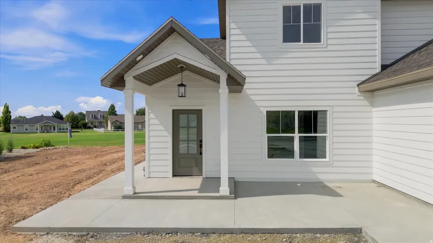 Welcoming front entry featuring a covered portico with gabled roofline and pendant lighting
