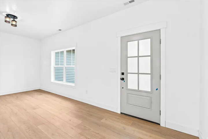 Light wood-finish flooring with white baseboards