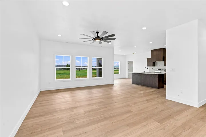 Open-concept living area featuring wood-finish flooring, recessed lighting, and a contemporary ceiling fan