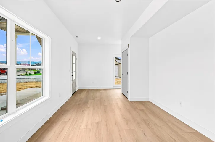 Recessed lighting, wood-finish flooring, white walls, white trim, and a glass-paneled entry door