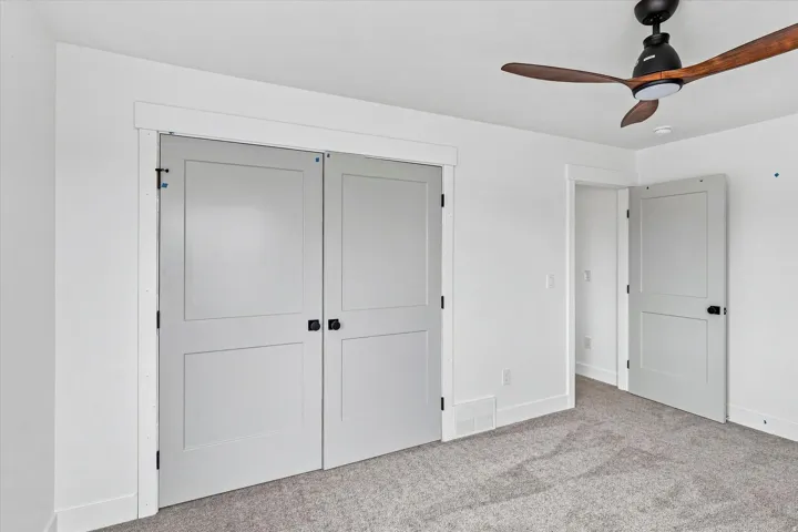 Recessed lighting and a ceiling fan with wood-finish blades