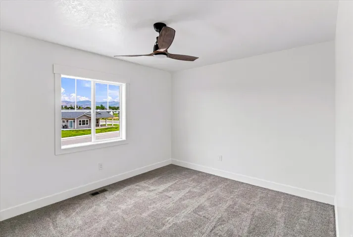 White walls, gray carpet, and a window with mountain scenery
