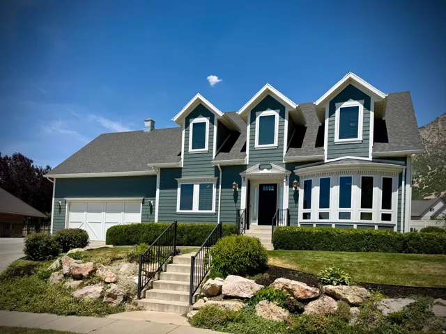 Traditional two-story residence featuring deep teal siding and white trim accents