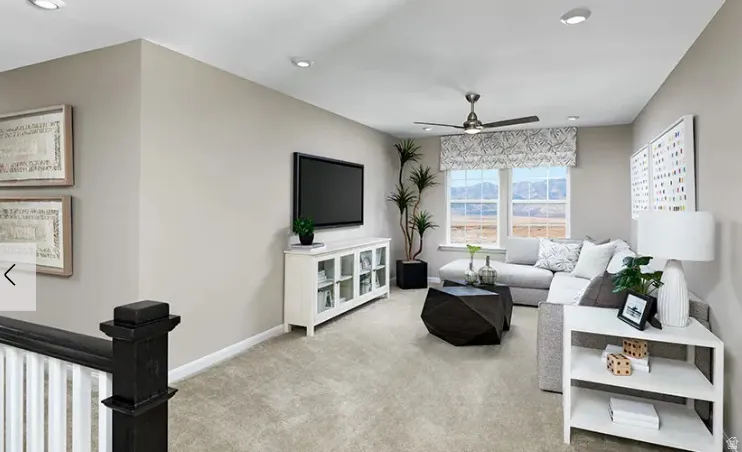 Carpeted living area featuring recessed lighting, a ceiling fan, and two large windows with mountain scenery