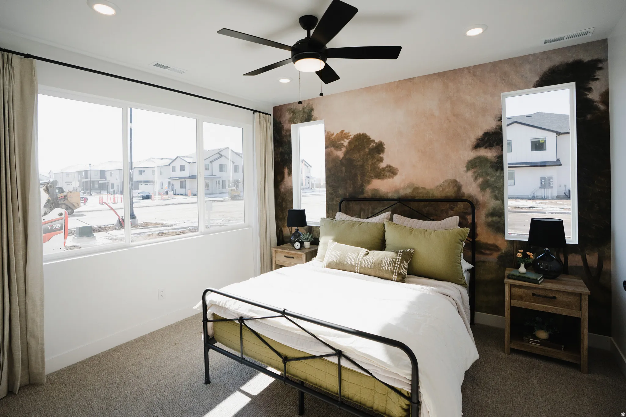 Bedroom featuring a prominent accent wall with a scenic mural, paired with a full-wall window array providing abundant natural light