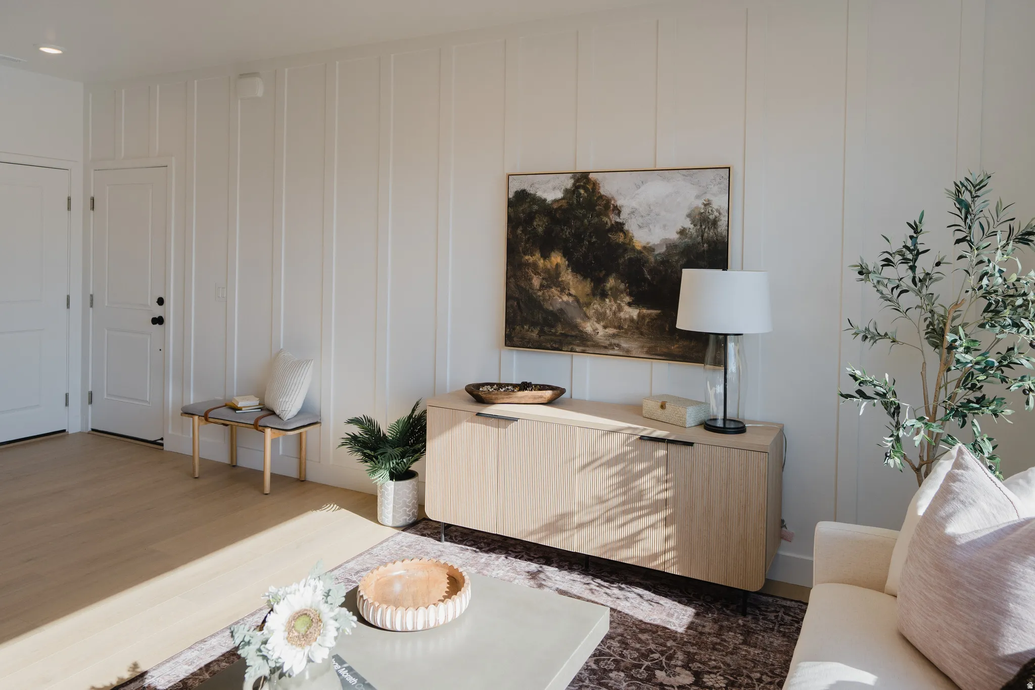 Light wood-finish flooring complements white vertical paneling