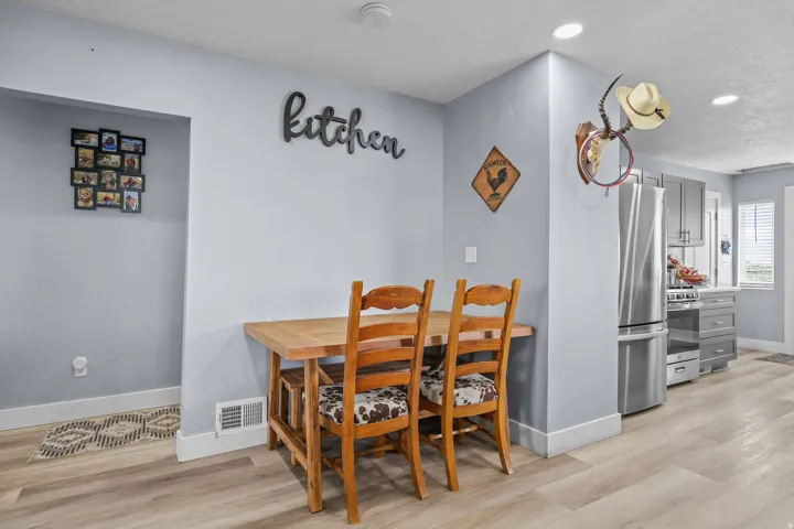 Kitchen area featuring wood-finish flooring, recessed lighting, and a stainless steel refrigerator