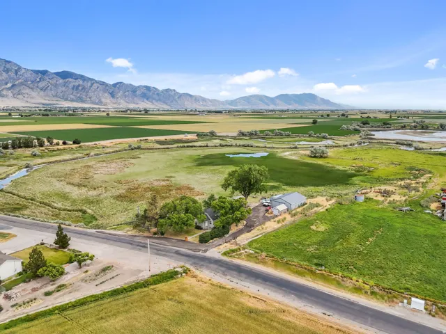 Expansive property featuring a residence, detached garage, and substantial open land