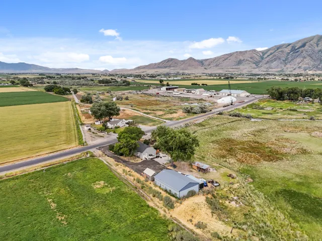 Expansive property featuring multiple structures, including a primary residence, a detached garage, and a large metal outbuilding