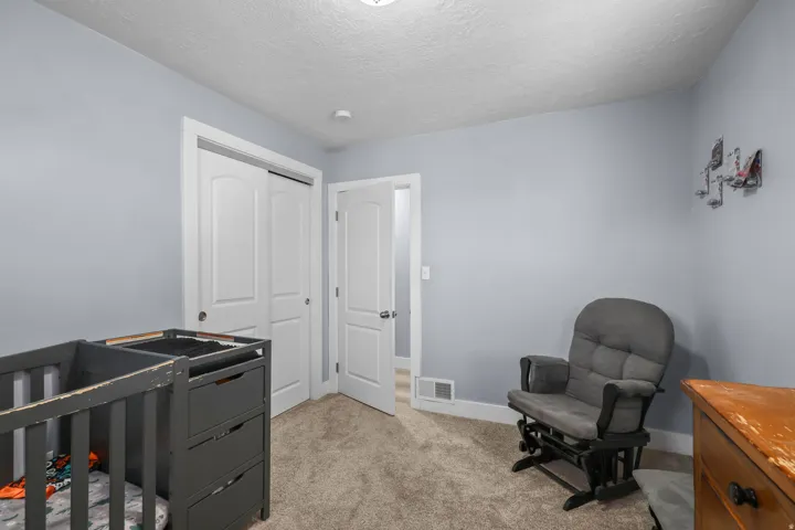 Bedroom with light gray walls and plush carpet flooring