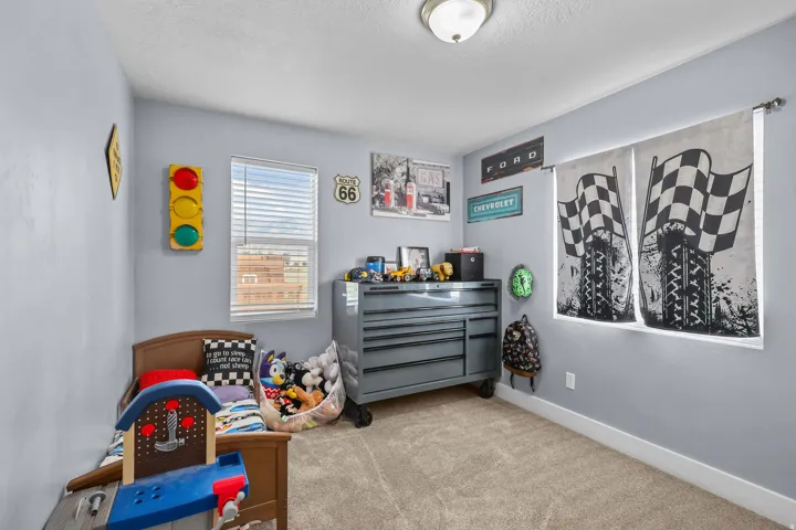 Carpeted bedroom with a single window featuring blinds