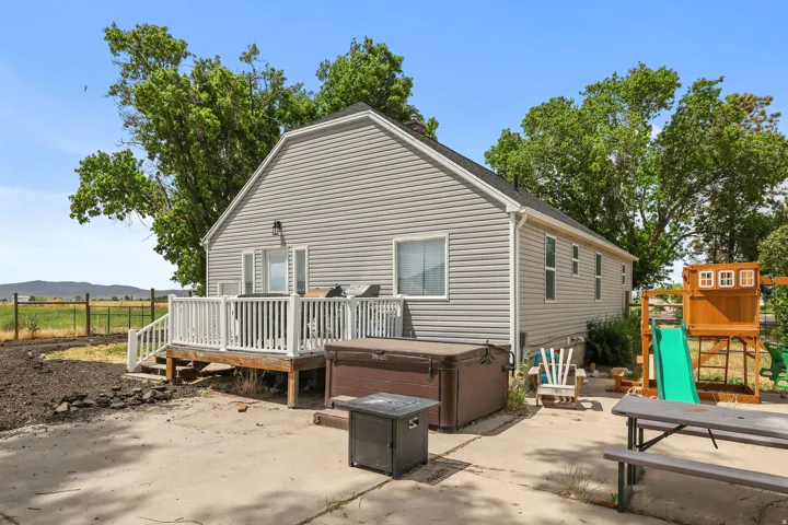 Exterior rear of the residence featuring grey horizontal siding and a white deck with railings